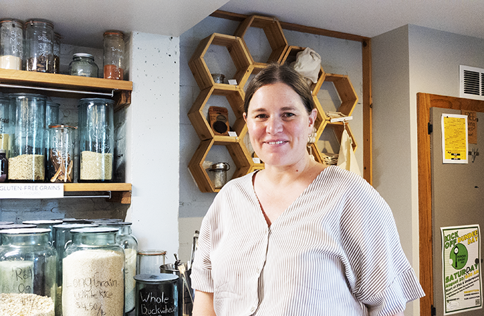 store owner wuth jars and wares in background